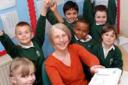 Headteacher June Cribb celebrates a good Ofsted report surrounded by pupils