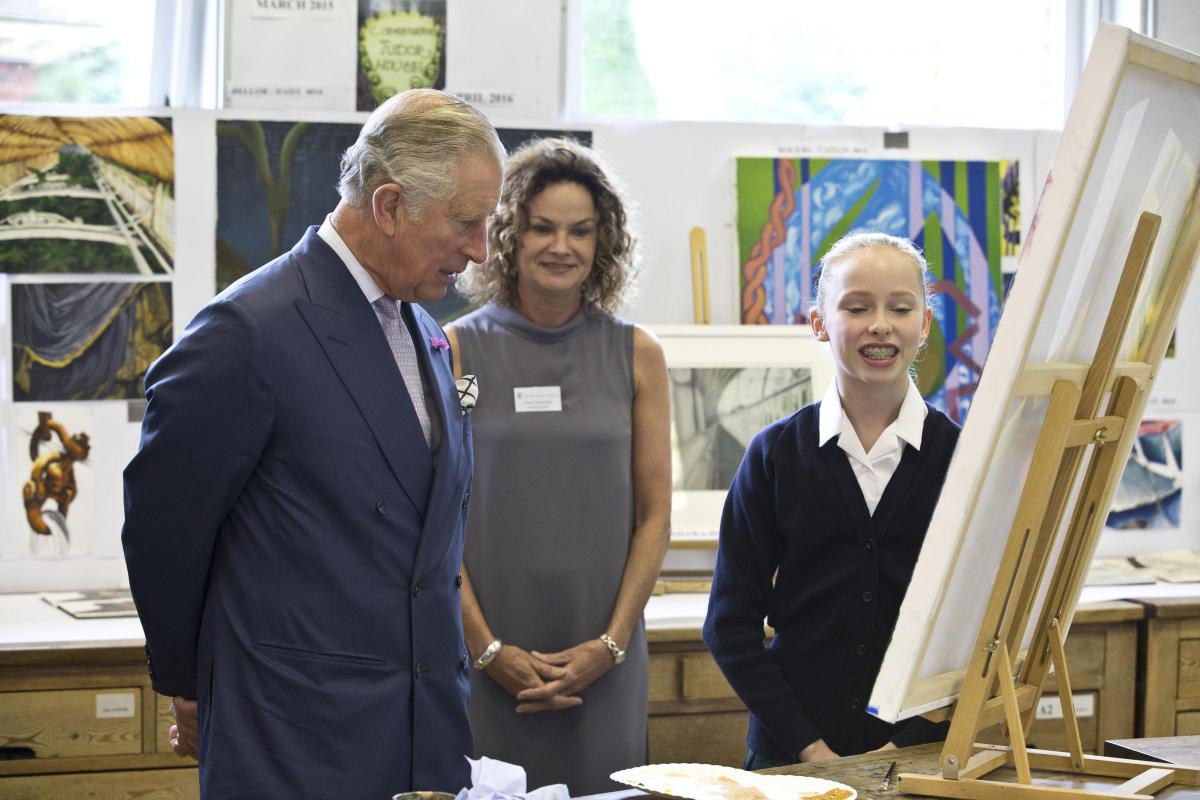 Prince Charles inspects a child's artwork