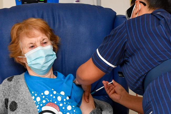 Margaret Keenan becomes the first patient in the United Kingdom to receive the Pfizer/BioNtech covid-19 vaccine at University Hospital, Coventry, administered by nurse May Parsons (Jacob King/PA)
