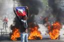 A demonstrator demands the resignation of Prime Minister Ariel Henry in Port-au-Prince (Odelyn Joseph/AP)