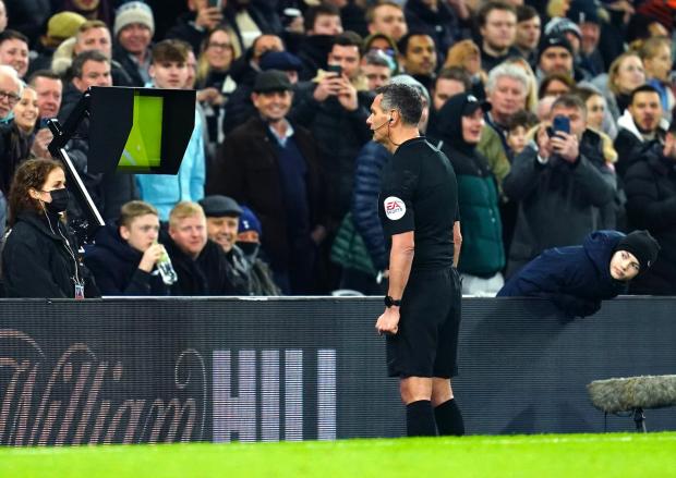 Richmond and Twickenham Times: Referee Andre Marriner checks a penalty decision on VAR during the Carabao Cup Semi Final, second leg match at the Tottenham Hotspur Stadium, London.